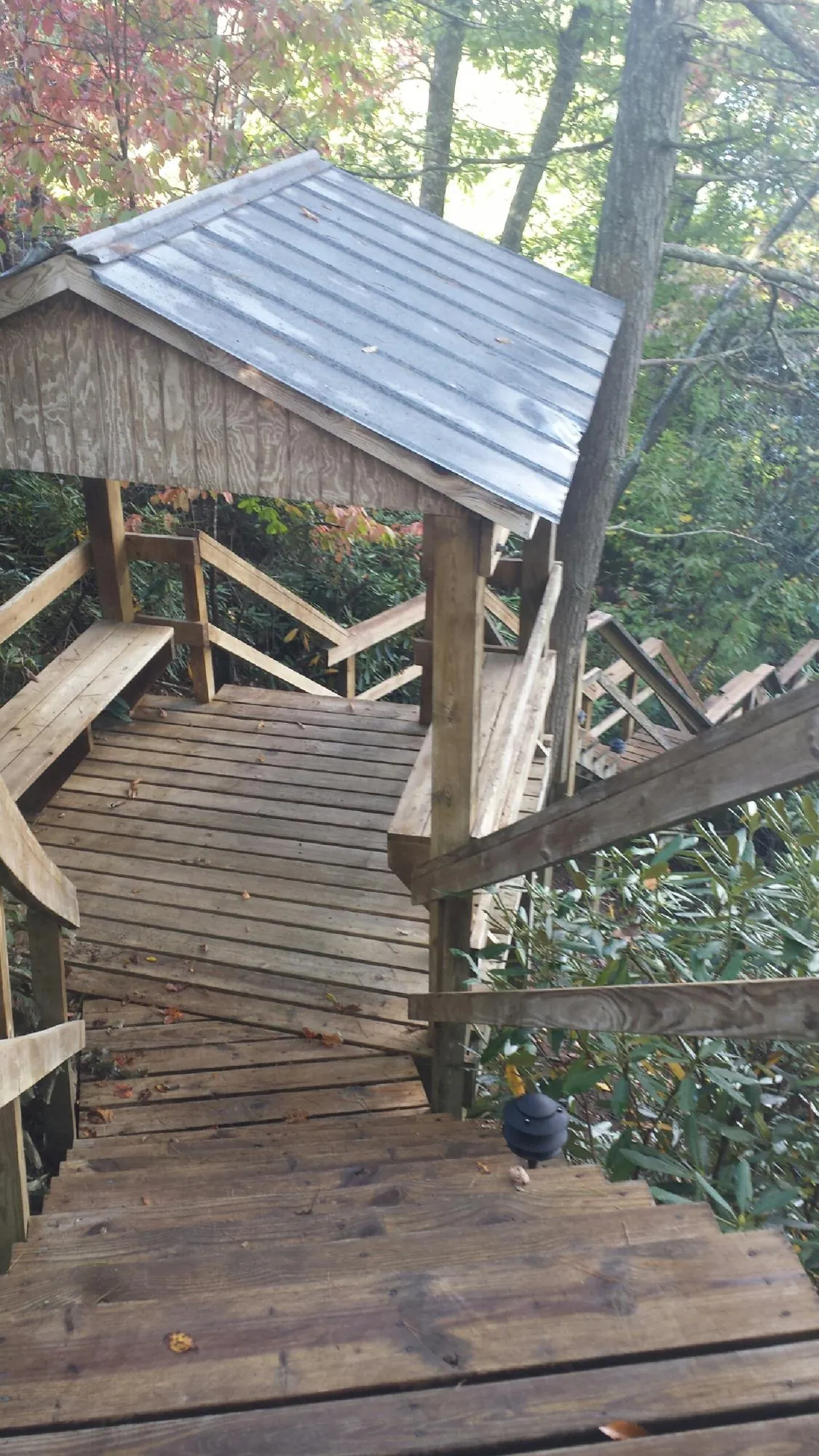 Metal roofed shelter over wooden steps on a wooded walkway — Skylight Repair & Installation work by our crew in Springfield Gardens