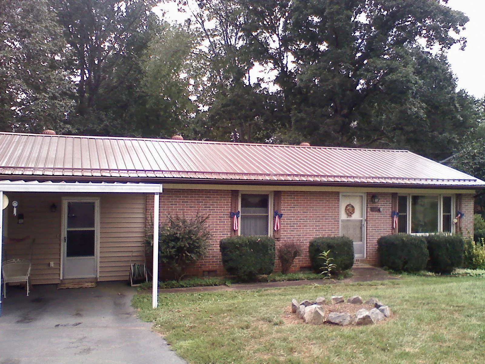 Bronze metal roof and carport on a brick ranch home — Roof Repair work by our crew in Springfield Gardens